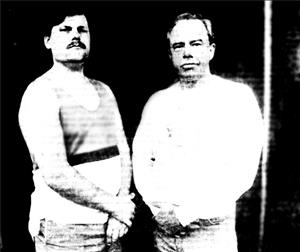 Two white men in front of a black wall